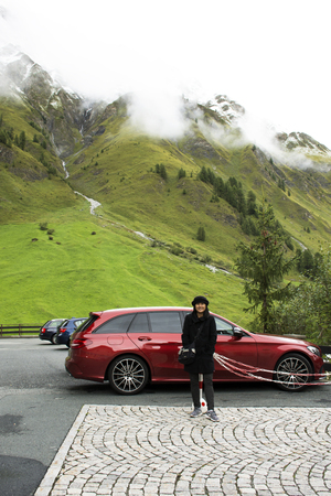 Asian thai woman posing for take photo with Alps mountain in car parking at Samnaun village on September 2, 2017 in Graubunden, Switzerlandのeditorial素材