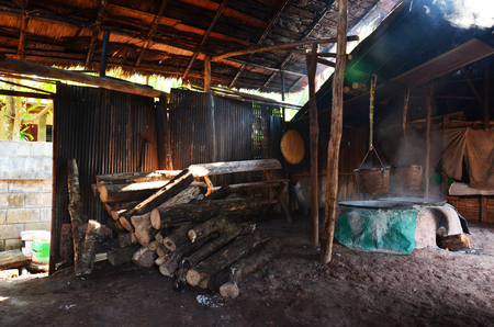 Thai people putting firewood in ancient old stove for make rock salt Indigenous Knowledge of bo kluea in Nan city in morning time at Ban Bo Kluea village on April 30, 2011 in Nan, Thailandのeditorial素材