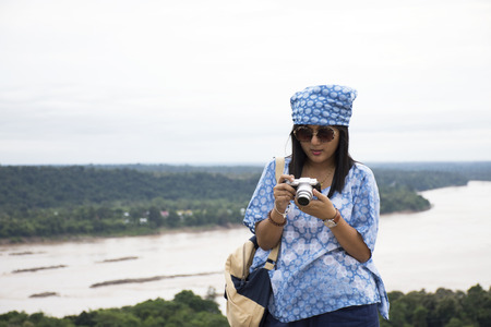 Asian travelers thai women travel and posing at viewpoint cliffs in Pha Taem National Park at Amphoe Khong Chiam in Ubon Ratchathani, Thailandの写真素材