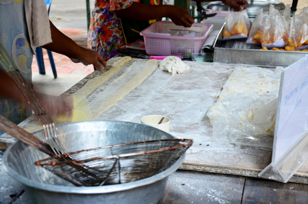 Thai people cooking deep-fried doughstick or Youtiao in market at Thailand の写真素材