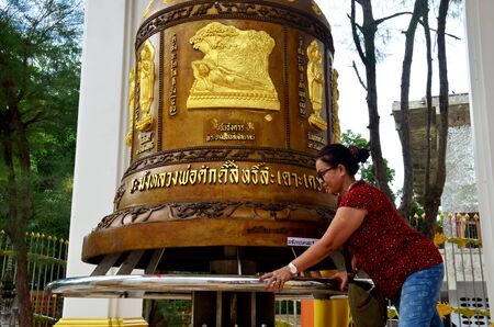Thai old woman people praying and rite rotate and spin big bell for blessing at Wat Tha Sung or Wat Chantharam temple on November 7, 2015 in Uthai Thani, Thailandのeditorial素材