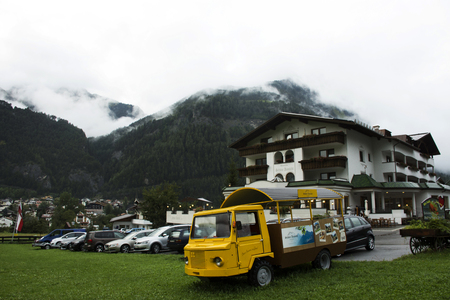 View cityscape and landscape and mountain with small truck at meadows while raining in evening time at Pfunds village on September 2, 2017 in Tyrol, Austriaのeditorial素材