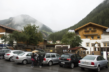 Travelers people bring luggage and bag from car go to resting at resort of Pfunds village while evening time and raining on September 2, 2017 in Tyrol, Austriaのeditorial素材