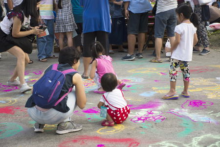 Thai children and parent travel and play painting powder color on ground in Bang Mod festival at Thung Khru District on December 9, 2017 in Bangkok, Thailandのeditorial素材