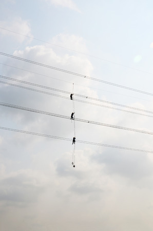 Electrician worker of Metropolitan Electricity Authority working repair electrical system on electricity pillar or Utility pole in countryside of Phra Nakhon Si Ayutthaya Province, Thailandのeditorial素材