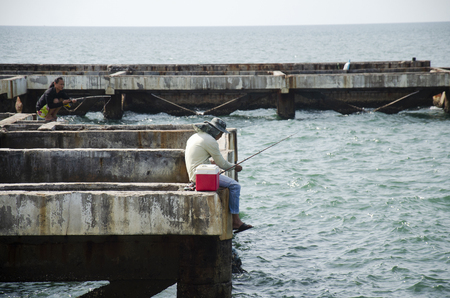 Thai angler or fisherman use fishing-rod fishing fish in the sea at coast of Laem thaen cape and Scenic Lookout Bangsaen beach on January 2, 2017 in Chonburi, Thailandのeditorial素材