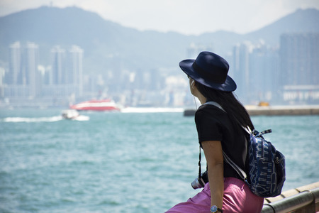 Travelers thai woman sitting relax and take photo with view landscape of island and sea at Victoria...