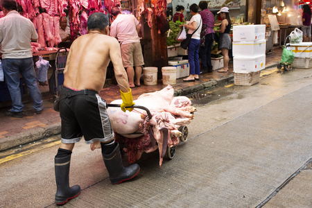 Chinese butcher people preparing meat for sale in local market at Bowrington Road Cooked Food Centre in Causeway Bay on September 3, 2018 in Hong Kong, Chinaのeditorial素材