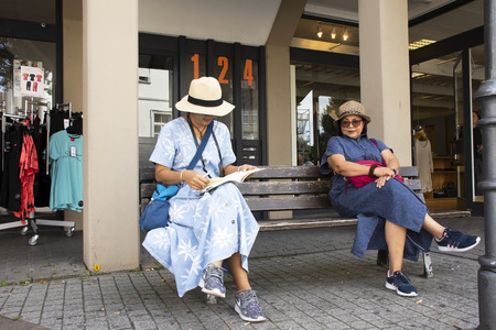 Asian thai women mother and daughter travel and sitting wait bus and tramway at Sandhausen street go to Heidelberg-Kirchheim on August 25, 2017 in Heidelberg, Germanyのeditorial素材
