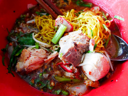 Special noodle spicy soup or noodles tom yum soup thai style with pork and other seasoning on table in local restaurant at Nonthaburi, Thailandの写真素材