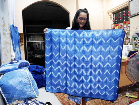 Thai woman sewing handmade tablecloth from indigo frabric natural color in night time at home on July 12, 2017 in Nonthaburi, Thailandの写真素材