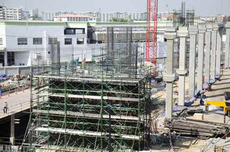 Asian people and thai workers with heavy machinery working builder new building at construction site high-rise building on scaffold at capital city in Bangkok, Thailand.の写真素材