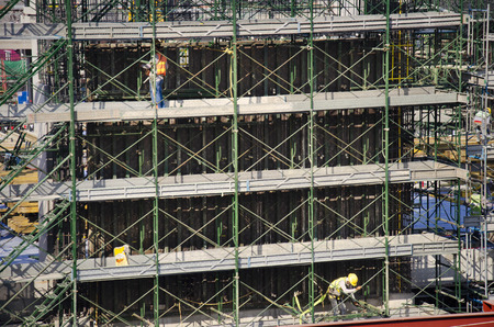 Asian people and thai workers with heavy machinery working builder new building at construction site high-rise building on scaffold at capital city in Bangkok, Thailand.の写真素材