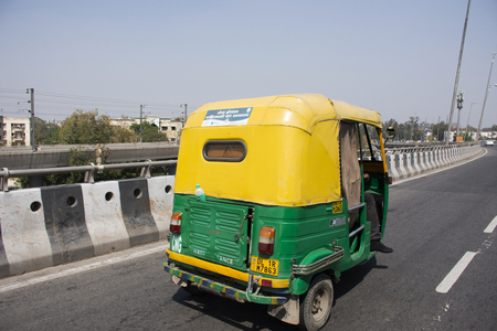 Indian people driving tricycle taxi on the street for send indian passengers and foreign travelers with traffic road at Delhi city on March 18, 2019 in New Delhi, Indiaのeditorial素材