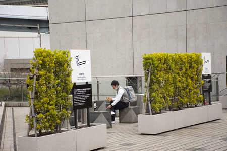 Tokyo, Japan - March 26, 2019 : Japanese people and foreign travelers relax and smoke cigarette at smoking area at tokyo big sight in Ariake town at Koto cityのeditorial素材