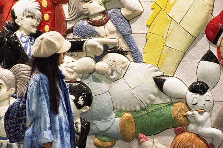 Tokyo, Japan - March 29, 2019 : Travellers thai women posing and portrait with wall art anime and hero japanese style in Ariake train JR railway Station at Koto Cityのeditorial素材