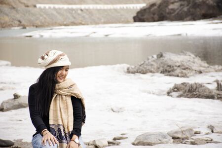 Travelers thai woman travel visit and posing portrait for take photo at view point of Confluence of the Indus and Zanskar Rivers while winter season at Leh Ladakh in Jammu and Kashmir, Indiaの写真素材