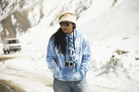 Travelers thai woman travel visit stand for take photo at Khardung La Road on top of himalaya mountain between go to Nubra valley village at Leh Ladakh while winter season in Jammu and Kashmir, Indiaのeditorial素材