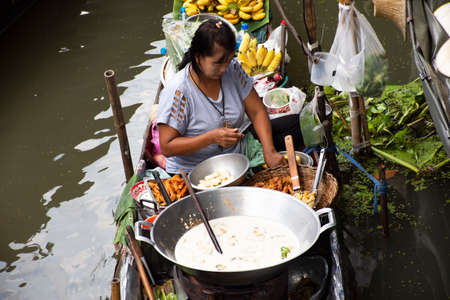 RATCHABURI, THAILAND - OCTOBER 30 : Thai people sale food product on wood boat in canal for thai and...
