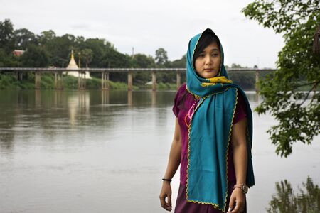 Travelers thai women alone wearing clothes mon ethnic style for take photo lonely at riverside of...