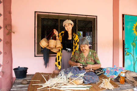 BUENG KAN, THAILAND - OCTOBER 3 : Thai old women made and working bamboo handmade for show traveler people at house in Life Community Museum at So Phisai city on October 3, 2019 in Bueng Kan, Thailandのeditorial素材