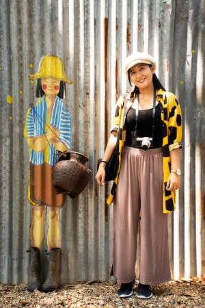 BUENG KAN, THAILAND - OCTOBER 3 : Thai women visit and posing portrait with graffiti painting on wall at Street art in Life Community Museum at So Phisai city on October 3, 2019 in Bueng Kan, Thailandのeditorial素材
