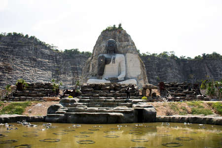 SUPHAN BURI, THAILAND - OCTOBER 28 : Big buddha carving on stone cliff of Wat Khao Tham Thiam for thai people travel visit and respect pray at U Thong city on October 28, 2019 in Suphanburi, Thailandのeditorial素材