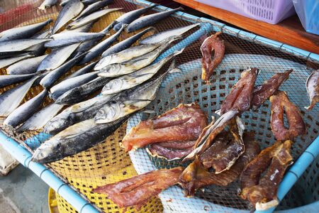 Dried sun fish for food preserves on wire sieve at outdoor for sale customer in local market shop of Ban Bang Krachao fishing village at Samut Sakhon, Thailandの写真素材