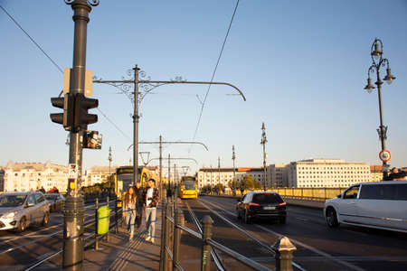 BUDAPEST, HUNGARY - SEPTEMBER 23 : Traffic road with train tram and Hungarian passengers and foreign travelers walking footpath beside Elizabeth Bridge road on September 23, 2019 in Budapest, Hungaryのeditorial素材