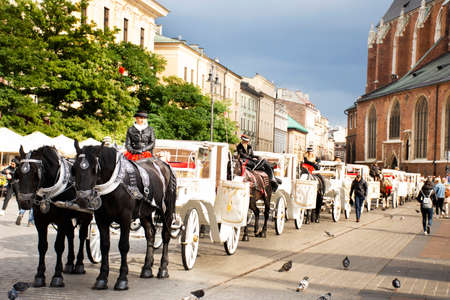Polish wait and ride horse drawn carriages for Pole people and foreigner travelers use service tour Krakow Old Town in Main Market Square at Stare Miasto on September 20, 2019 in Lesser, Polandのeditorial素材
