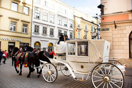 Polish wait and ride horse drawn carriages for Pole people and foreigner travelers use service tour Krakow Old Town in Main Market Square at Stare Miasto on September 20, 2019 in Lesser, Polandのeditorial素材