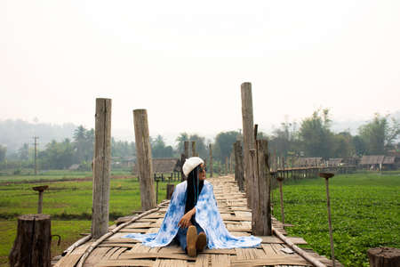 Travelers thai women wearing indigo shawl travel visit and sit on Su Tong Pae bamboo wooden bridge for take photo at Phu Sa Ma temple while PM 2.5 Dust situation at Pai city in Mae Hong Son, Thailandのeditorial素材