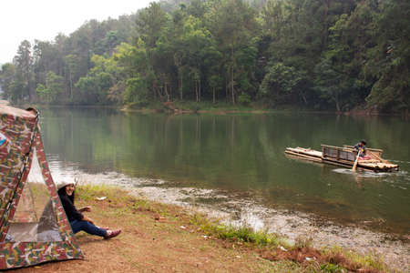 Thai women traveler travel visit Pang Ung pine forest and tent camping and bamboo rafts in Pang Oung lake or Switzerland of Thailand in authentic Chinese village Ban Rak Thai in Mae Hong Son, Thailandのeditorial素材