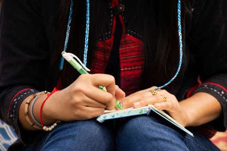 Travelers thai women visit and sitting writing note on the book for memory of detail between journey travel on rowing bamboo rafts on Pang Ung lake in Pang Oung forest park in Mae Hong Son, Thailandのeditorial素材