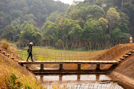 Travelers thai women visit walking on wooden suspension bridge in Pang Ung lake in Pang Oung forest park or Switzerland of Thailand in authentic Chinese village Ban Rak Thai in Mae Hong Son, Thailandのeditorial素材