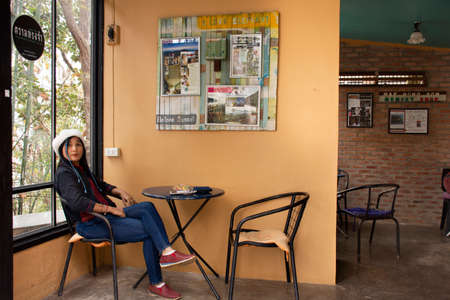 Travelers thai woman posing portrait for take photo with interior decoration furniture of cafe coffee shop at Wat Phra That Doi Kong Mu Temple on February 28, 2020 in Mae Hong Son, Thailandのeditorial素材