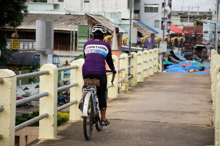 Life of thai people riding biking bicycle on small bridge cross Sakae Krang river go to Uthaithani city and local market on October 20, 2020 in Uthai Thani Province of Thailandのeditorial素材