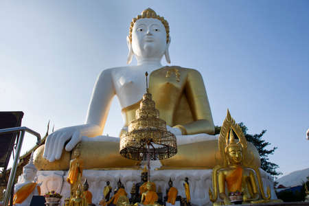 Big golden buddha image statue of Wat Phra That Doi Kham or Temple of the Golden Mountain for thai people and foreign travelers travel visit and respect praying at Mae Hia in Chiang Mai, Thailandの写真素材