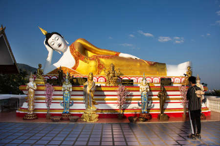 Beautiful reclining buddha image statue of Wat Phra That Doi Kham temple for thai people and foreign travelers travel visit respect praying at Mae Hia city on November 10, 2020 in Chiang Mai, Thailandのeditorial素材