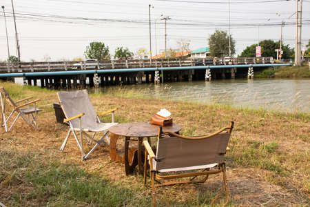 Exterior decoration and furniture modern style furniture at out door of cafe coffee shop on grass park beside irrigation canal at Bangbuathong city rural countryside of Nonthaburi in Bangkok, Thailandの写真素材