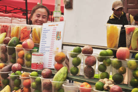 Laotian vendor sale soft drinks water and juice fruits shake for lao people and foreign traveler travel visit in local shop at Louangphabang Street night Market on April 7, 2016 in Luang Prabang, Laosのeditorial素材