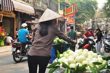 Vietnam woman people push bicycle cart hawker on road sale guava fruits to vietnamese people and foreign travelers on Hang Buom walking street at Hoan Kiem city on April 12, 2016 in Hanoi, Vietnamのeditorial素材