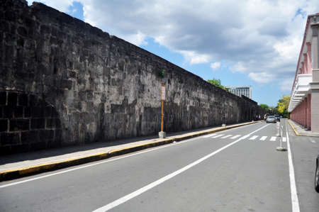 View landscape cityscape and modern building department of filipino people driving riding biking walking with traffic road on Muralla street and old dirty wall at Maynila city in Manila, Philippineの写真素材