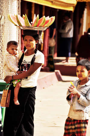 Local burma lifestyle burmese mother and son daughter sale watermelon to people and foreign travelers buy eat drink at Shwezigon Pagoda Paya at Bagan or Pagan on February 2, 2013 in Mandalay, Myanmarのeditorial素材