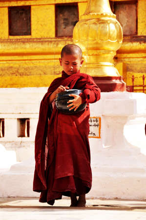 Burmese children novice stand for receive donate from burma people and foreign traveler visit respect praying at Shwezigon Pagoda Paya temple at Bagan or Pagan on February 2, 2013 in Mandalay, Myanmarのeditorial素材