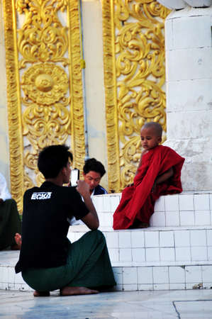 Burmese children novice and father family travel visit respect praying ancient tradition ritual Maha Myat Muni Buddha statue at Mahamuni Paya Temple on February 3, 2013 in Mandalay, Myanmar or Burmaのeditorial素材