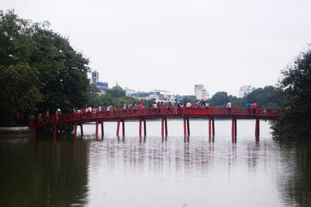 Hoan Kiem pool or Lake of the Returned Sword with The Huc red bridge entrance of Ngoc Son temple for vietnamese people and foreign travelers travel visit at Hoan Kiem on July 7, 2012 in Hanoi, Vietnamのeditorial素材