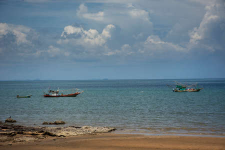 Thai local wooden small fishing boat float in sea ocean at Sairee sand beach in Gulf of Thailand and...