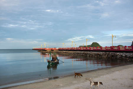 Thai fishermen maintenance fix repair wood fishing boat ship floating in sea at Prachuap Bay in Gulf of thailand and Saphan saranwithi red bridge on September 6, 2021 in Prachuap Khiri Khan, Thailandのeditorial素材