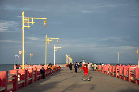 Thai people foreign travelers travel visit rest relax and exercise playing sport skateboard on Saphan saranwithi red bridge at Prachuap bay beach on September 6, 2021 in Prachuap Khiri Khan, Thailandのeditorial素材